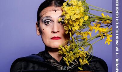 Carmela de Feo mit Blumen im Gesicht, führt zum Kalendereintrag