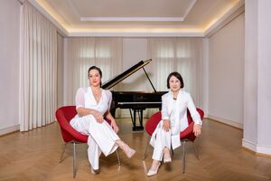 Franziska Dannheim und Jeong-Min Kim auf roten Seeseln vor Flügel sitzend