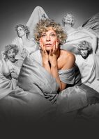 Anna Schäfer im Bett umgeben von lauter Anna Schäfers