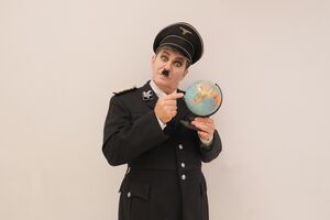 Andreas Guglielmetti als der große Diktator in Uniform mit Globus in der Hand