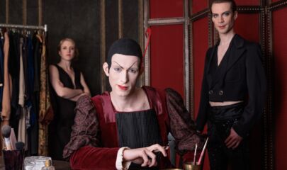 Mephisto in Garderobe mit zwei stehenden Schauspielern dahinter, führt zum Kalendereintrag