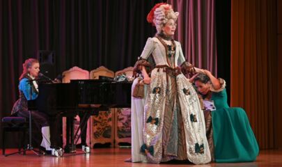 Marie Antoinette mit knieender Zofe rechts und Zofe am Klavier links, führt zum Kalendereintrag