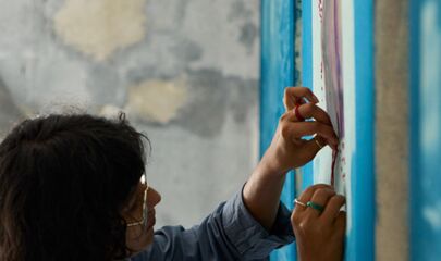 Alka Dass im Studio arbeitet an einem Bild, führt zum Kalendereintrag