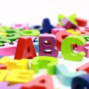 Bunte Alphabetbuchstaben liegen verstreut. Die ABC Buchstaben stehen aufrecht. Link führ zu Angeboten für Kitas und Schulen